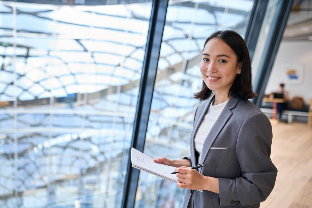 Smiling Young Asian Business Woman Manager Wearing Suit Holding