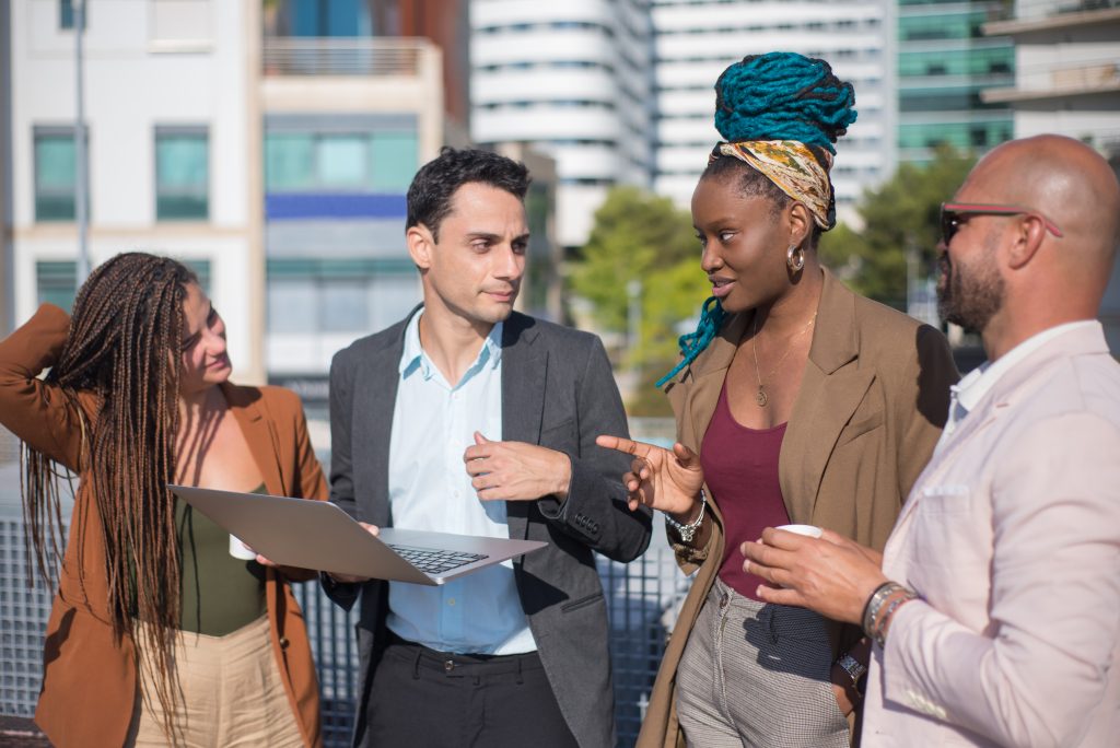 Smart-dressed business people discussing matters on terrace roof -The Spanish Group