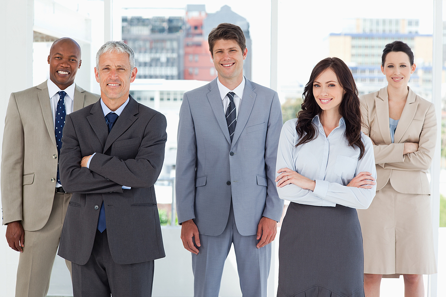 Young smiling executive standing in the middle of the room among